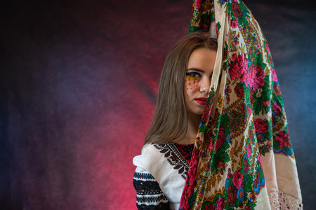 Beautiful ukrainian young woman wear ethnic embroidered blouse at dark background, independence day, folk and ethnic conceptの写真素材