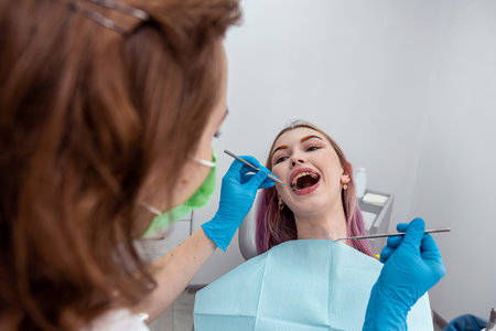 photo top view of a smiling woman's mouth during treatment in a dental clinic by a female dentist. Dental health concept.の写真素材