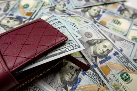 Full wallet of dollar lying on us money banknotes, financial wealth saving investment concept