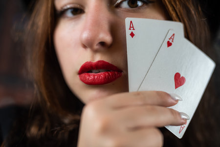 Casino woman with red lips holding ace with seductive lips and teeth. face close up Poker or other...