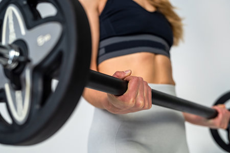 attractive strong adult woman with beautiful athletic body doing barbell exercises for abs. isolated on white studio wall. Fitness. bodybuilding Health care.の写真素材