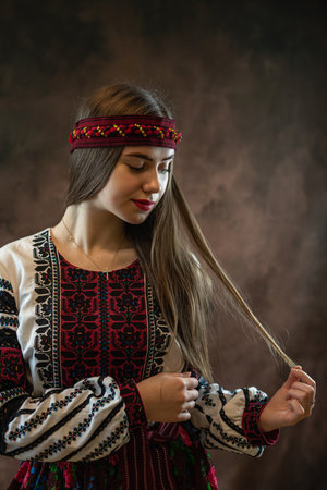 Beautiful ukrainian young woman wear ethnic embroidered blouse at dark background, independence day, folk and ethnic conceptの写真素材