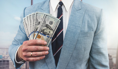 Closeup 100 one hundred us dollar banknotes in male hands. successful businnman holding moneyの写真素材