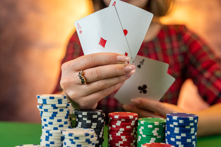 hands of a young Caucasian woman with a beautiful manicure at the casino table close-up. poker game conceptの写真素材