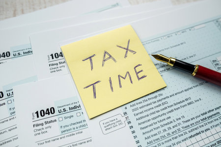 yellow sticker with world Tax Time on 1040 tax form, Tax concept deadlineの写真素材