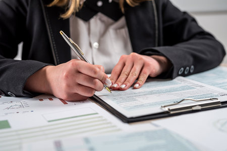 closeup businesswoman filling out the 1040 tax form 2022. financial paperwork concept. Tax timeの写真素材
