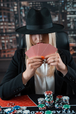 Portrait of gambling lucky woman playing poker with card and chips at casino. Gambling concept, lifestyleの写真素材