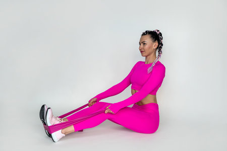 one caucasian woman doing pilates and fitness with sports bands isolated silhouette on white...