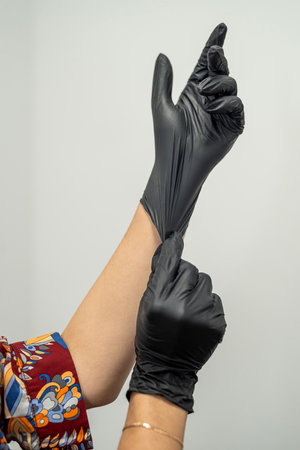 depilation master puts on gloves before the procedure. the concept of depilation