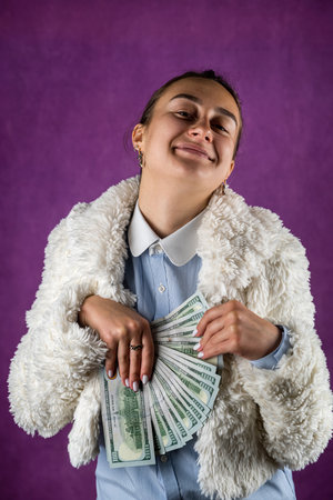 Photo of coquettish lady holding cash fan with dollars isolated white color background. finances. a large amount dollars in handの写真素材