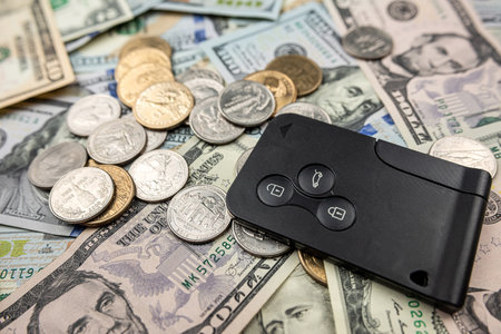 buying a car dollar coinand paper cash with keys. Insurance concept. Sell or rentの写真素材
