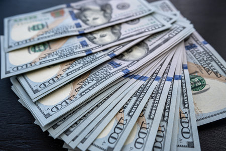 Pile of new 100 dollar banknotes bills on black. Finance concept. Rich and saving