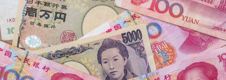 Asian money - Chinese yuan with Japanese yen bill, finance backgroundの写真素材
