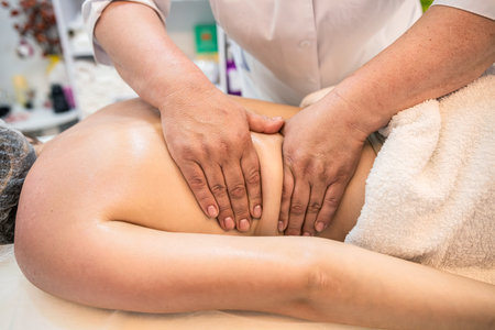 hands of a female masseur with the help of oils while massaging the back of a beauty client. concept of spa treatments. massageの写真素材