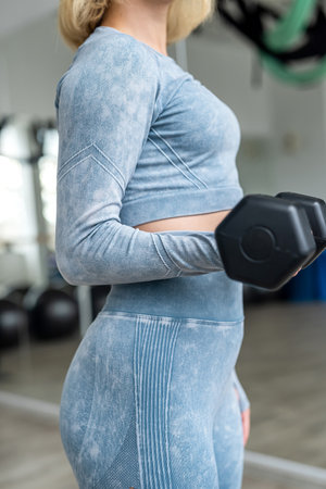 young fitness woman lifts dumbbells in the gym for a toned figure. sport concept. healthの写真素材