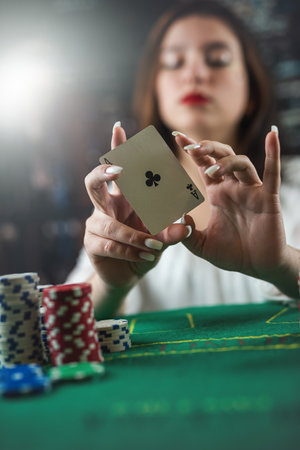 young luxurious woman came to play poker at a local casino. gambling concept. a woman wins in poker. cards. chipsの写真素材