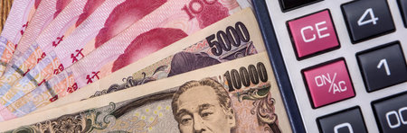 Asian money - Chinese yuan with Japanese yen bill, finance backgroundの写真素材