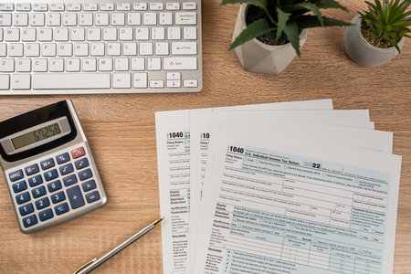 1040 Tax form documents with pen and computer keyboard on office desk. Nobody, paperwork accounting conceptの写真素材