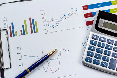 business graph documents and calculator, supplies on office desk table. Top view. Saving concept