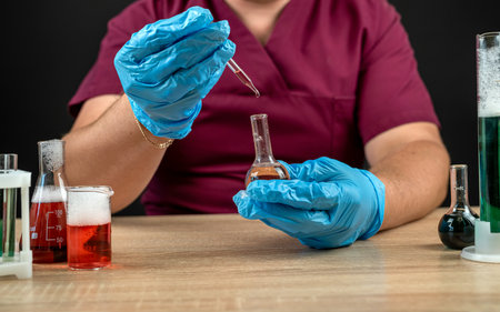 male scientist in lab coat mixing reagents from glass flasks, all for chemistry experiment