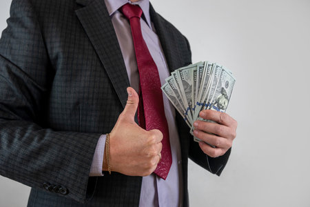 money US dollar bills in hand businessman isolated on grey. US bank noteの写真素材