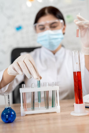 Caucasian beautiful lab worker doing test or research in clinical laboratory with color sample on...