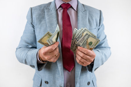 money US dollar bills in hand businessman isolated on grey. US bank noteの写真素材