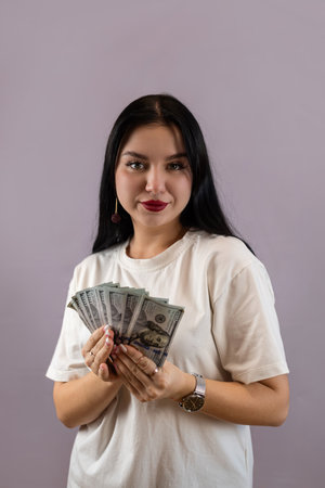 pretty young woman holding dollar money over pink background. Finance saving conceptの写真素材