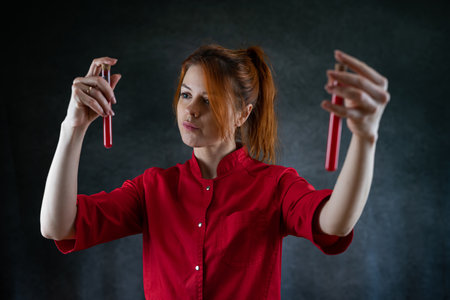 Doctor in red uniform examining blood at test tube, protection against pandemic. Health care worker
