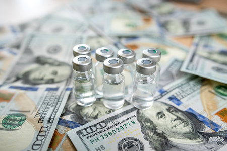 coronavirus vaccine or other in bottle on dollar paper background, Concept of vaccination and...