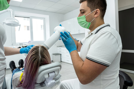 male and female dentists take professional photos of a girl's oral cavity. photo before and after. treatment progressの写真素材