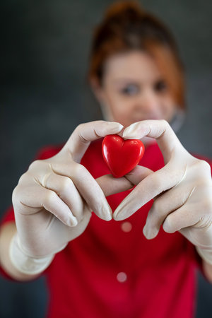 Prettycaucasian woman doctor holding a red heart, isolated. Medical concept treatmentの写真素材