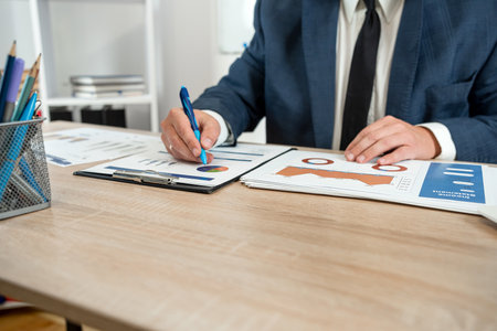 Business man in suit calculate annual profit by duty with finance document computrer and calculator...