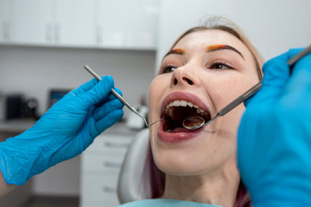 Image of a satisfied young woman sitting in a dental chair in a medical center while a professional...