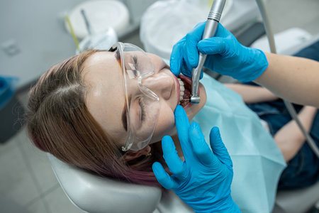 young girl sits in a medical chair while a dentist treats her teeth in a dental clinic. healthy oral cavity. teeth treatmentの写真素材