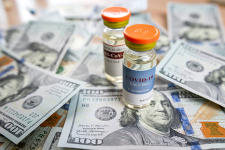 coronavirus vaccine or other in bottle on dollar paper background, Concept of vaccination and treatment against coronavirus, pharmacy is very expensive costの写真素材