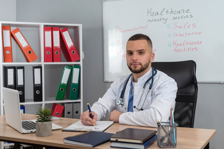 Caucasian man doctor working in his office at the hospital for diagnosis in medicare clinic. Analyze test resultsの写真素材