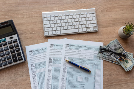 PC keyboard US dollar pen 1040 tax form on office table desktop. Tax time  conceptの写真素材