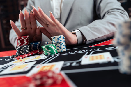 Gambler female hands going all-in, stack of colored poker chips at casino. Gambling conceptの写真素材