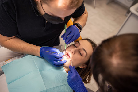 Close-up photo of woman with open mouth with mirror for dental equipment. Caries healing. Examination of the dentist.の写真素材