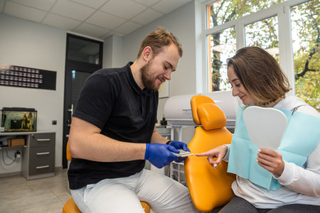 young dentist consults a female patient in a dental practice. dentistry an experienced dentist. teethの写真素材