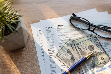 2023 Form 1040 with pen and glasses us dollar money on desk. Income tax conceptの写真素材
