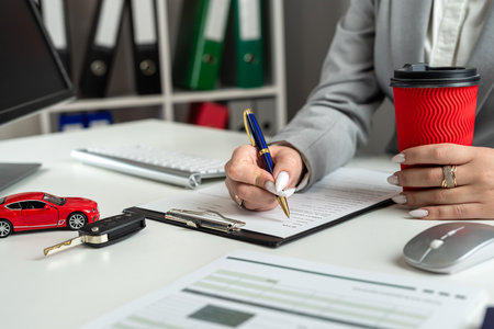 Woman manager prepare to sign papers documents to purchase or rest car in dealership office. Car finance and insurance conceptの写真素材
