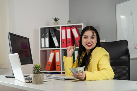 Business caucasian woman holding bundle of money dollar for payment salary and income at office. Workplaceの写真素材