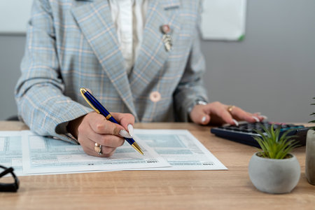Female accountant work with 104 tax form at office. Audit concept, paperworkの写真素材