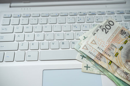 Pln 200 zloty Polish money on laptop keyboard, finance saving conceptの写真素材