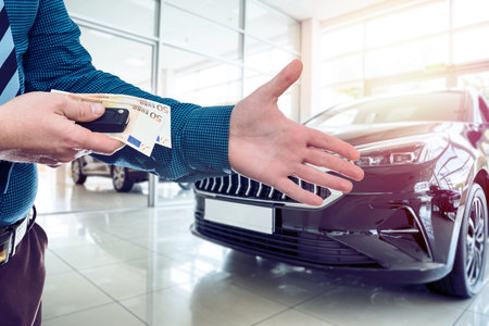 Man hold euro money in car showroom. Concept of buy or rent new car.の写真素材