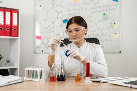 Woman scientist chemist mixing liquid in laboratory glass with pipette, medicine and research in chemistry. Pharmaceutical research conceptの写真素材