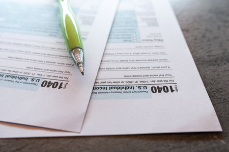 Green pen lies on 1040 U.S tax form. Revenue Service tax filing deadlineの写真素材