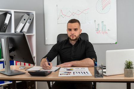 Man working and analyzing financial reports project at modern office. Financial advisor accounting concept.の写真素材